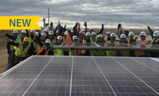 Volunteers celebrating in front of solar for Denver Housing Authority.