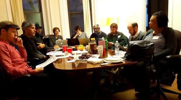 The 51st State Co-op participants meet around a table.